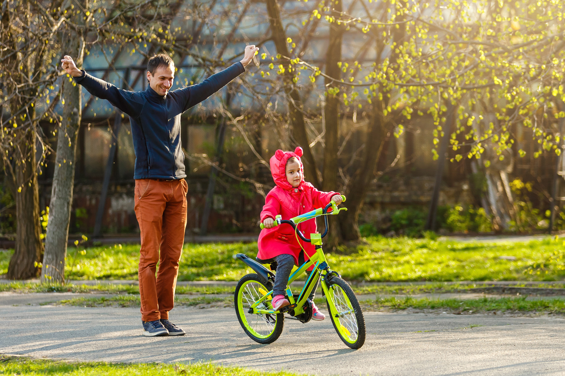 Father teaching daughter to ride a bike